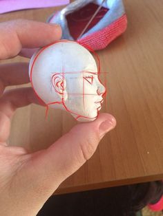 a person holding up a piece of paper with an image of a man's head on it