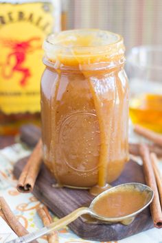 a glass jar filled with liquid sitting on top of a wooden table next to cinnamon sticks