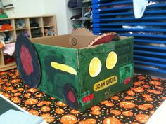 a cardboard box that is shaped like a truck with eyes and nose painted on it