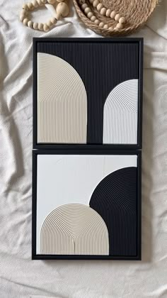 two black and white plates sitting on top of a bed next to a straw hat