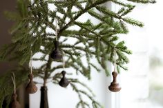 ornaments hanging from the branches of a christmas tree in front of a window sill