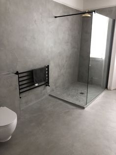 a bathroom with a toilet, shower and glass door in it's center area