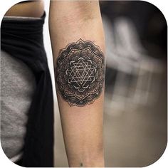 a person with a tattoo on their arm and the image of a sacred symbol in the middle