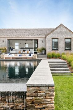 a house with a pool in front of it and water running from the back yard