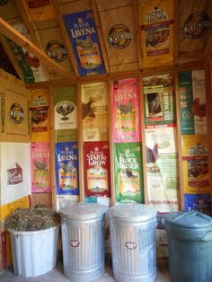 three buckets are sitting next to each other in front of several different colored banners