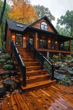 a wooden deck with steps leading up to a small cabin style home in the woods