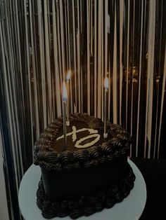 a chocolate cake with two candles on top