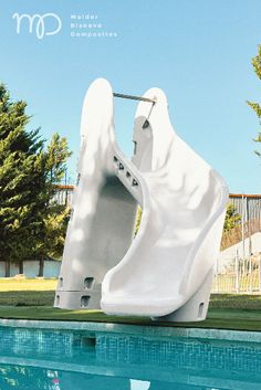 a large white sculpture sitting next to a swimming pool