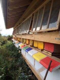 the side of a building with many different colored boards on it's sides and windows