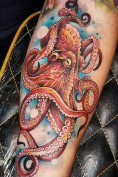 an octopus tattoo on the leg of a man's arm with watercolors