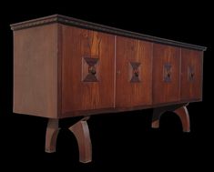 a wooden cabinet with four doors and three legs