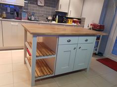 a kitchen island made out of wood with drawers on the bottom and shelves above it