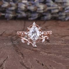 a close up of a ring on top of a wooden table with flowers in the background