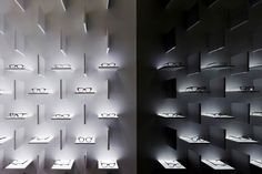 there are many shelves that have glasses on them in the room and one is lit up with lights