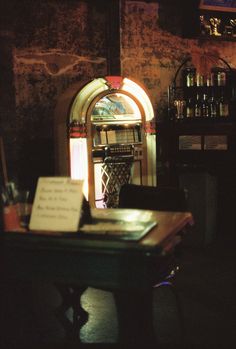 an old - fashioned jukebox sits in the corner of a dark room with writing on it