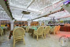 the inside of a restaurant with tables and chairs covered in green cloths, decorated for christmas