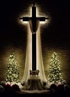 the cross is lit up with christmas lights