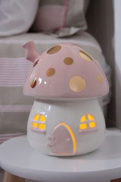 a pink and white mushroom shaped night light on top of a table