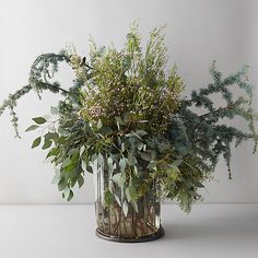 a glass vase filled with lots of greenery