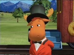 a cartoon moose wearing a top hat and bow tie standing in front of a train