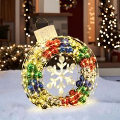 a lighted christmas ornament in the snow