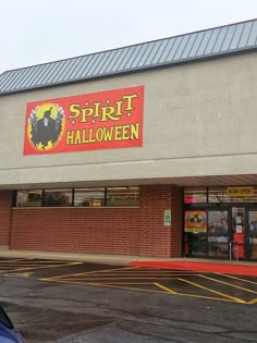 a spirt halloween store is shown on the side of the street in front of a blue car