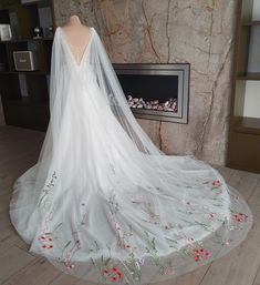 a wedding dress on display in front of a fireplace