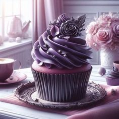 a cupcake with purple frosting sitting on top of a plate next to a window