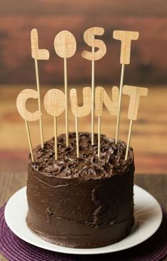 a chocolate cake sitting on top of a plate with wooden sticks sticking out of it