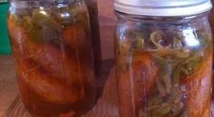 two mason jars filled with pickled vegetables on a table