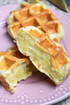 some waffles are on a pink plate