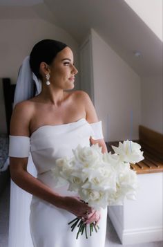 a woman in a wedding dress holding a bouquet of flowers