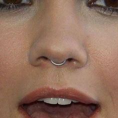 a close up shot of a woman's nose with piercings