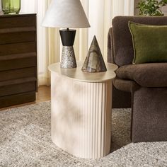 a lamp sitting on top of a table in a living room next to a chair