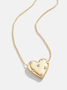 Every jewelry box needs a heart silhouette, and the Melina Necklace just might be our favorite choice. A chunky gold heart pendant is strung on a classic gold chain and adorned with tiny, pretty glass stones. We love this one layered with a few other dainty chain styles to really round out your stack. Minimal Gold Jewelry, Gold Chain Necklaces, Lizzie Hearts, Gold Heart Pendant, Heart Shaped Jewelry, Heart Pendant Gold, Gold Necklace Designs, Layered Jewelry, Valentines Jewelry