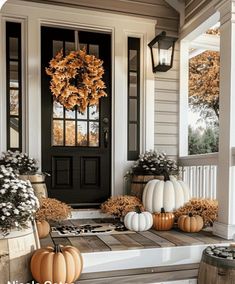 front porch decorated for fall with pumpkins and gourds