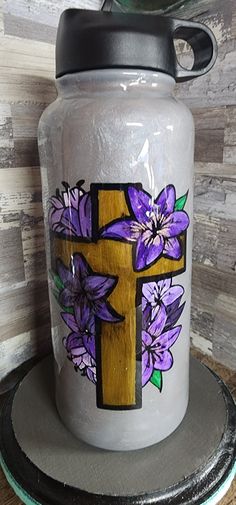 a cross with purple flowers painted on it