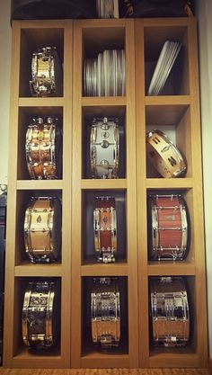 a wooden shelf filled with lots of different types of musical instruments on top of each other