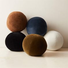 four different colored balls sitting on top of each other in front of a white wall