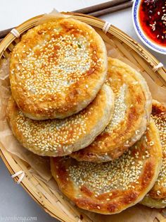 sesame seed breads are piled on top of each other in a wicker basket