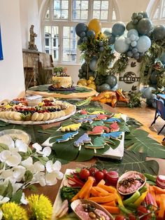 a table filled with lots of food and balloons