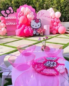 a hello kitty themed birthday party with balloons and tableware set up on the lawn