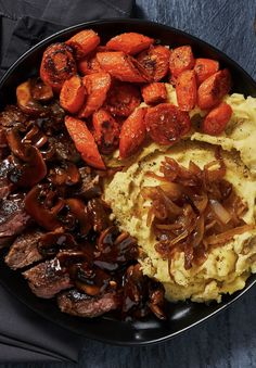 a plate with meat, mashed potatoes and carrots