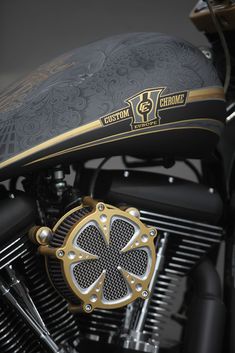 a close up of a motorcycle with a shamrock on the front tire and gold accents