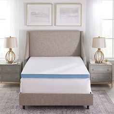 a bed with a blue mattress on top of it in a bedroom next to two nightstands