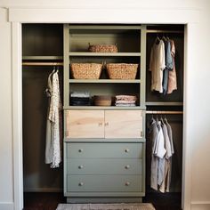 an organized closet with drawers, baskets and clothes hanging on the wall next to it