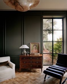 an image of a living room with a chair and table in front of the window