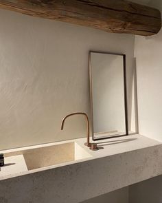 a bathroom sink with a mirror and faucet next to it on top of a counter