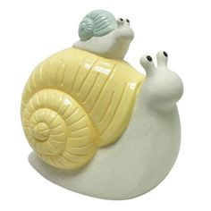 a ceramic snail figurine with two snails on it's back