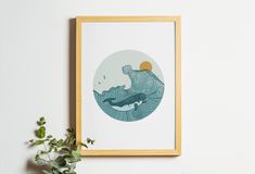 a plant is sitting on a shelf next to a framed art print with an image of a whale swimming in the ocean